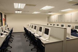 an office full of desks and computers in rows